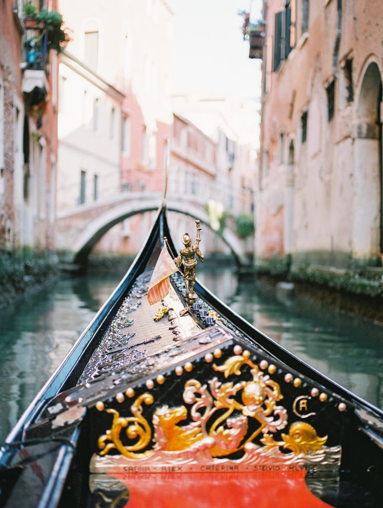 A close up shot of the front of a gondola with a gold statue image photographed by Kelley Williams Photography a Venice Italy wedding photographer. 