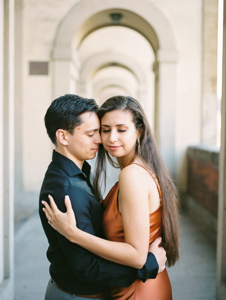 Couple wandering the beautiful cobblestoned streets of Florence Italy for their honeymoon, the beautiful sights of Ponte Vecchio, the Arno river, and more, image photographed by Kelley Williams a Florence Italy wedding photographer