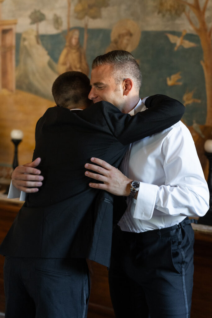 Groom hugging his groomsmen, Abbazia San Pietro in Valle wedding, image taken by Kelley Williams a wedding photographer in Umbria Italy