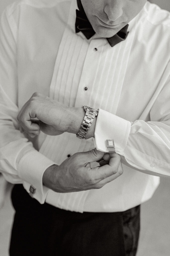 Black and white close up of the groom with his cufflinks, Abbazia San Pietro in Valle wedding, image taken by Kelley Williams a wedding photographer in Umbria Italy
