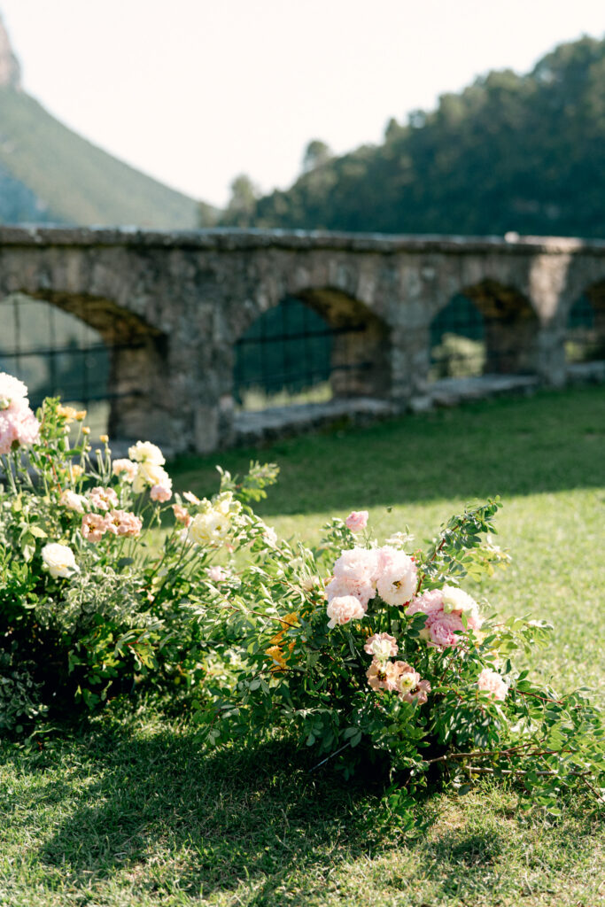 Close up of flowers in the grounded ceremony arch, Abbazia San Pietro in Valle wedding, image taken by Kelley Williams a wedding photographer in Umbria Italy