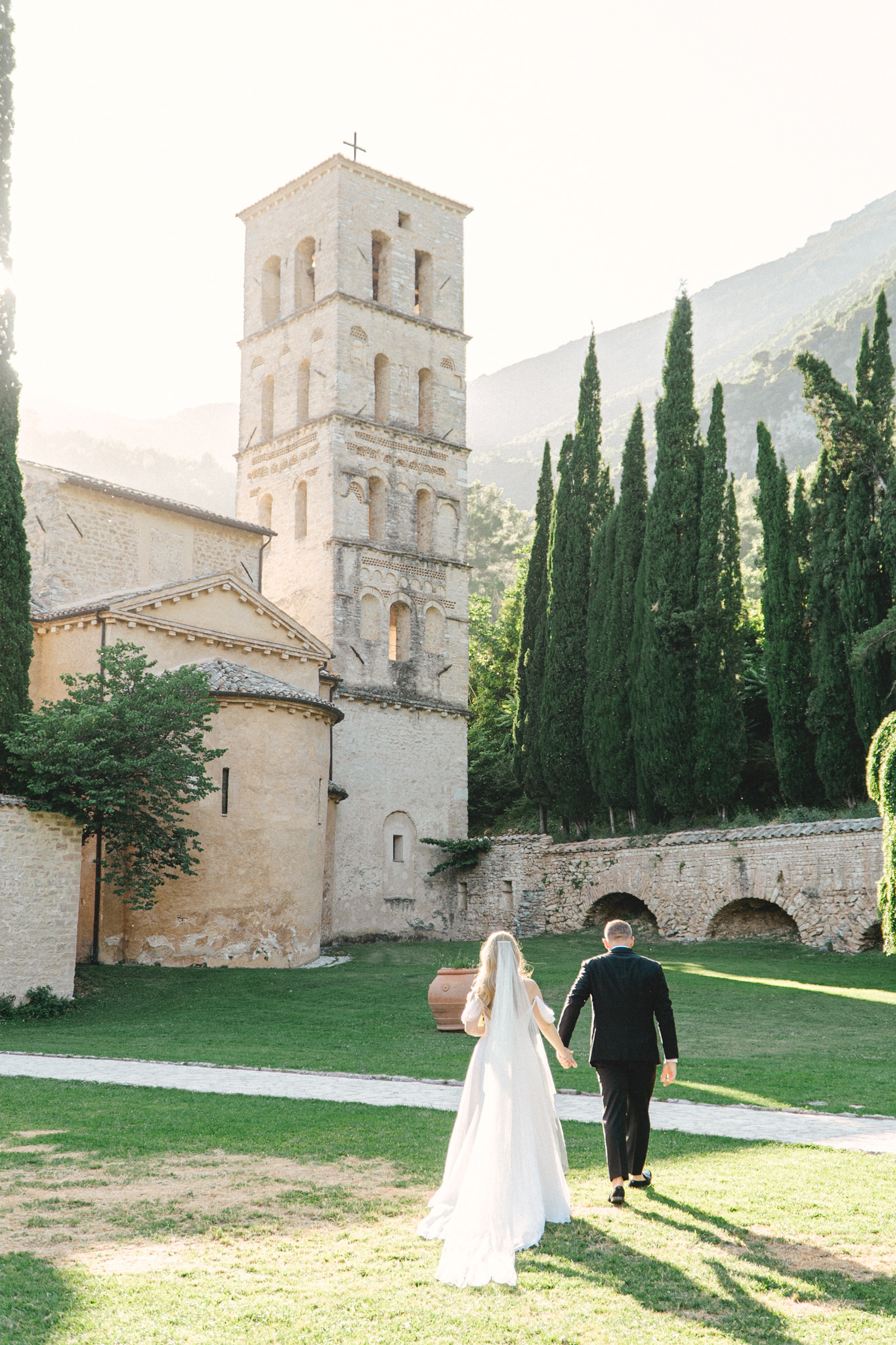 Wedding couple getting married in front of 15 people overlooking a green valley at Abbazia San Pietro in Valle, image taken by Kelley Williams a wedding photography in Umbria Italy