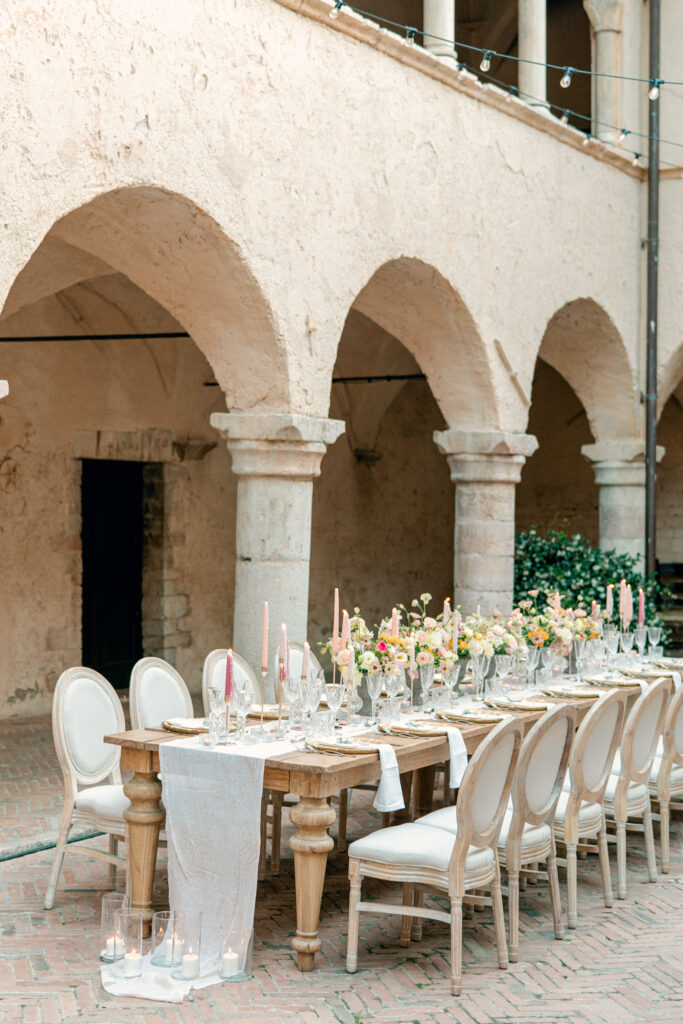 Wedding reception table with candles and one long table, Abbazia San Pietro in Valle wedding, image taken by Kelley Williams a wedding photographer in Umbria Italy