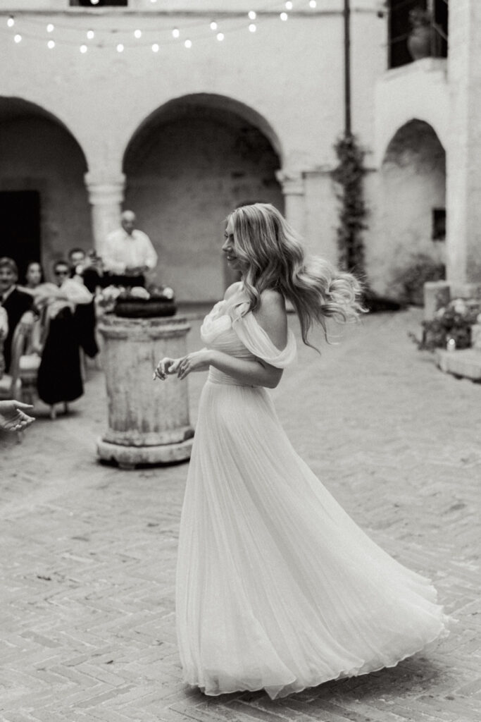 Black and white photo of bride dancing, Abbazia San Pietro in Valle wedding, image taken by Kelley Williams a wedding photographer in Umbria Italy