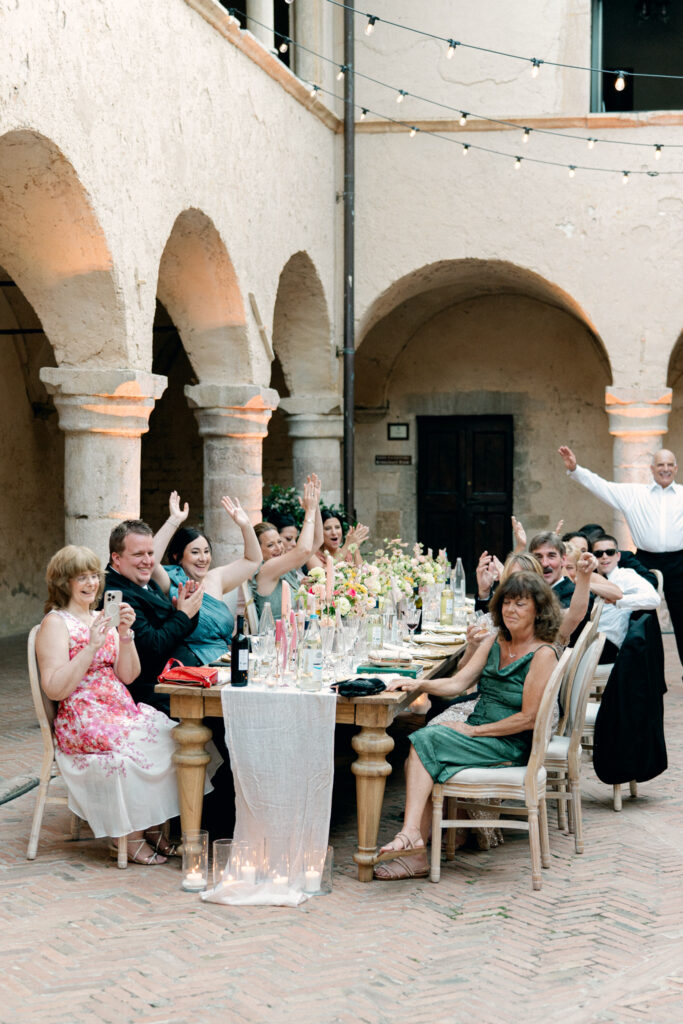 Wedding guests clapping and cheering the bride and groom on as they dance, Abbazia San Pietro in Valle wedding, image taken by Kelley Williams a wedding photographer in Umbria Italy