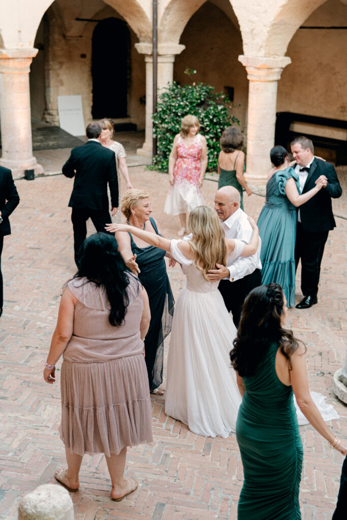 The bride hugging her parents on the dance floor, Abbazia San Pietro in Valle wedding, image taken by Kelley Williams a wedding photographer in Umbria Italy