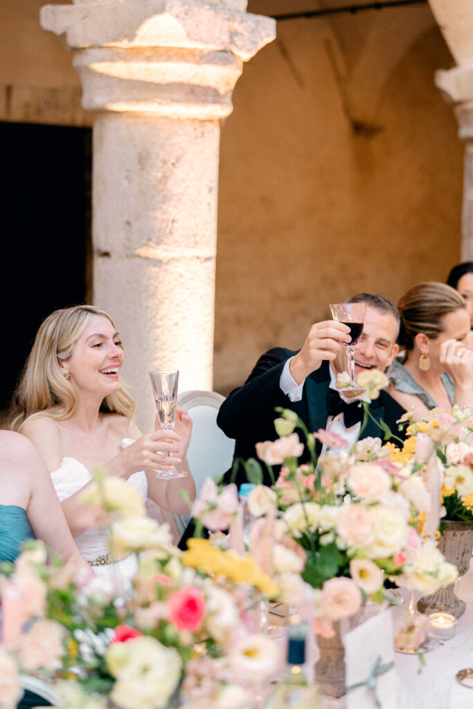 wedding couple smiling and cheersing with their wine, Abbazia San Pietro in Valle wedding, image taken by Kelley Williams a wedding photographer in Umbria Italy