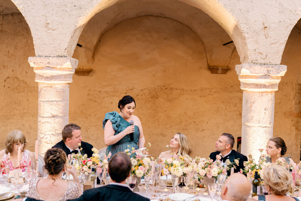 The maid of honor giving a toast after dinner, Abbazia San Pietro in Valle wedding, image taken by Kelley Williams a wedding photographer in Umbria Italy